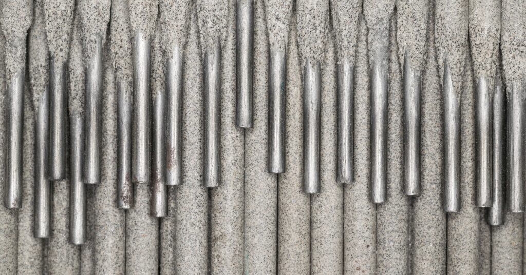 A high-definition, close-up shot of a collection of light gray electrodes, stacked on top of each other, with the metal pieces visible.