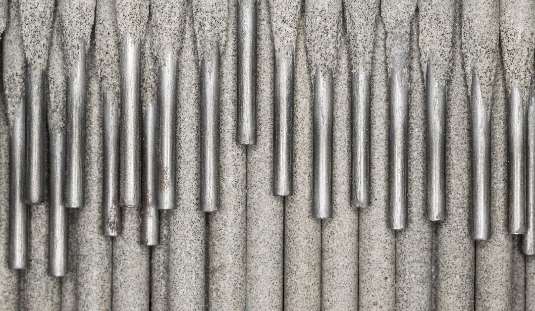A high-definition, close-up shot of a collection of light gray electrodes, stacked on top of each other, with the metal pieces visible.