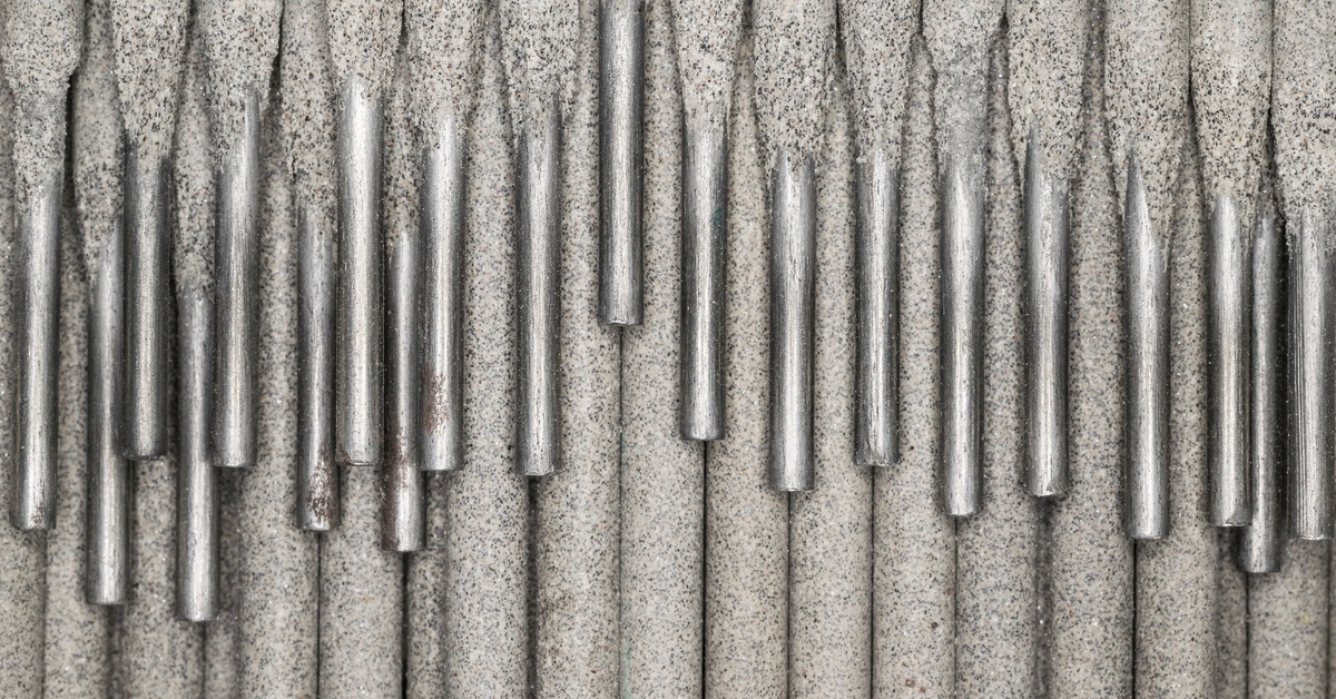 A high-definition, close-up shot of a collection of light gray electrodes, stacked on top of each other, with the metal pieces visible.