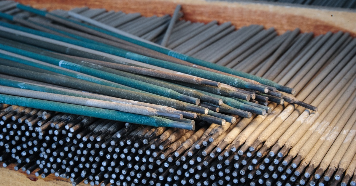 An expansive collection of black, gray, and blue welding electrodes organized on top of wooden pallets.